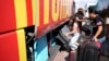 People load their belongings onto a bus as they evacuate from the southern Israeli town of Sderot, Oct. 15, 2023.