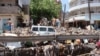 FILE - People inspect damage caused by flooding on a street in Aden, Yemen, April 22, 2020.