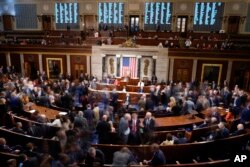 Members walk on the House floor in the House chamber during a roll call vote on the motion to adjourn as the House meets for a second day to elect a speaker and convene the 118th Congress in Washington, Jan. 4, 2023.