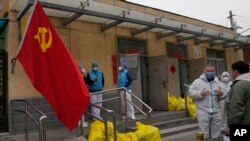 2022年3月17日北京一个封闭社区外，工作人员在聊天。