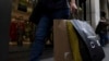 FILE - A shopper carries bags down Fifth Avenue on Black Friday, Nov. 25, 2022, in New York City. Holiday sales rose as shoppers showed some resilience during the most important shopping season despite surging prices on everything from food to rent.