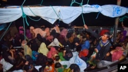 ২০২১ সালের ৩০ ডিসেম্বর, রোহিঙ্গা শরণার্থীরা একটি কাঠের নৌকায় ইন্দোনেশিয়ার উত্তর আচের ক্রুয়েং গেউকুইহ বন্দরে পৌঁছানোর পর।