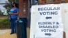 Carteles dirigidos a los votantes en un colegio electoral de Cobb County, en Marietta, Georgia, para una votación temprana, el 17 de octubre de 2022.