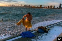 FILE - "The Great Lake Jumper" Dan O'Conor towels off after taking a plunge into the frigid waters of Lake Michigan, Jan. 27, 2023, in Chicago.