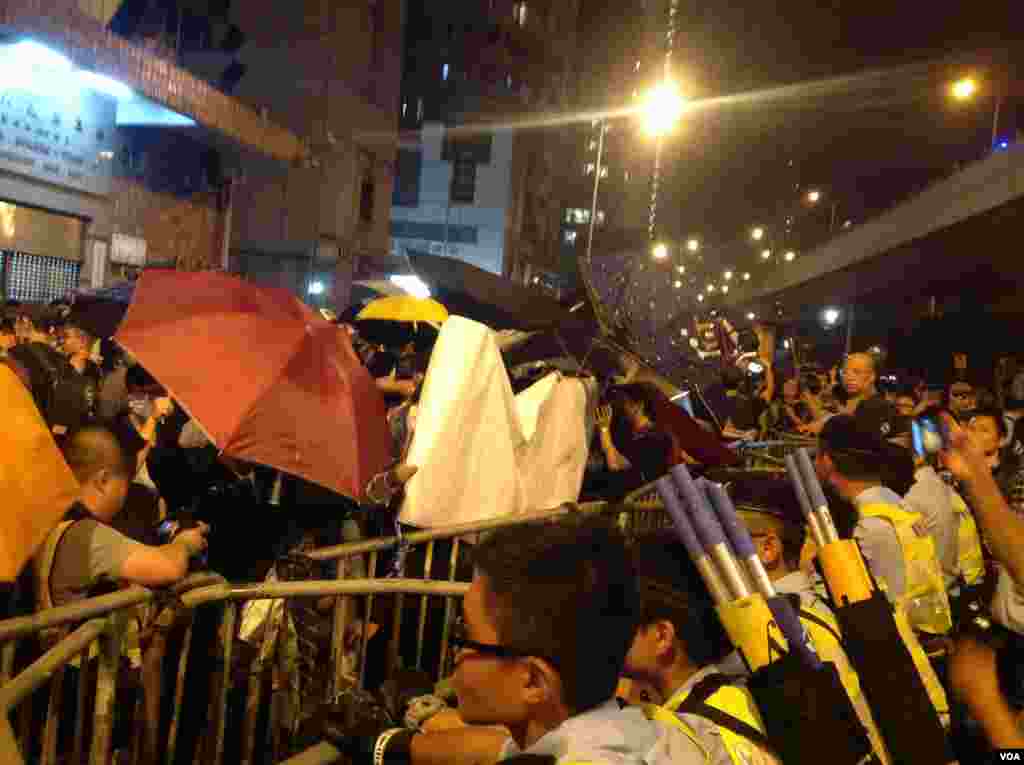 8点半左右,示威者手举雨伞再次冲击警方防线,警方则狂喷辣椒喷剂还击。警方调派大批警员增援,并将配备防暴头盔的警员派至一线与示威者对峙。警方不断呼吁示威者保持冷静,不要冲击警方防线,要求示威者尽快离开。