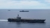 FILE - In a photo provided by the U.S. Navy, U.S. warships sail together in formation, in the South China Sea, July 6, 2020.