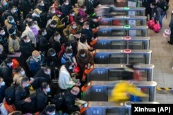 中国江苏省苏州火车站的旅客排队准备进站。中国一年一度的春运开始了 (2023年1月7日) 评论