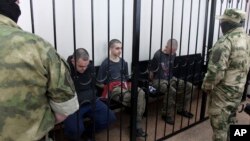 Фото: громадяни  Британії Ейден Еслін та Шон Піннер та громадянин Марокко Брагім Саадун в проросійському суді в Донецьку, 9 червня 2022 року. (AP Photo)