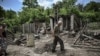 A man walks through the yard of a damaged house after shelling in which two people were killed in the city of Lysychansk in the eastern Ukrainian region of Donbas on June 13, 2022.