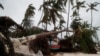 ডোমিনিকান প্রজাতন্ত্রের পুন্তা কানাতে হারিকেন ফিওনার তাণ্ডবের পর সমুদ্রতীরে ধ্বংসস্তূপের মধ্যে দাঁড়িয়ে আছে একজন ব্যক্তি। ১৯ সেপ্টেম্বর, ২০২২। 
