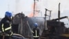 A handout image made available by the Odessa City Council Telegram channel, July 24, 2022, shows Ukrainian firefighters battling a fire on a boat burning in the port of Odessa after missiles hit the port on July 23, 2022. (Odessa City Council Telegram ch