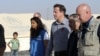 Britain's PMr David Cameron walks with Jordanian Foreign Minister Nasser Judeh and UNHCR representative to Jordan Andrew Harper during his visit to Al-Zaatri refugee camp in the Jordanian city of Mafraq, November 7, 2012. 