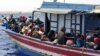 FILE - Illegal migrants who attempted to sail to Europe, sit in a boat carrying them back to Libya, after their boat was intercepted at sea by the Libyan coast guard, at Khoms, Libya, May 6, 2015.