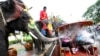 FILE - An elephant blows water from its trunk onto tourists in Ayutthaya province, central Thailand. A recent report by World Animal Protection found that Thailand is home to three-quarters of all elephants kept in captivity for entertainment purposes.