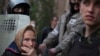 An elderly woman watch as a group of pro-Russian demonstrators storm the military Prosecutor's Office in Donetsk, Ukraine, May 4, 2014. 