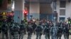 Riot police stand guard as lawyer and newly elected district councillor arrive at the Polytechnic University to meet the left-over protesters in Hong Kong, Nov. 25, 2019. 
