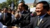 Opposition leader of Cambodia National Rescue Party Sam Rainsy, center, delivers a speech next to his Deputy President Kem Sokha, right, during a gathering to mark Human Rights Day, in front of National Assembly, in Phnom Penh, Cambodia, Wednesday, Dec. 10, 2014. (AP Photo/Heng Sinith
