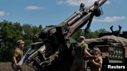 Українські військовослужбовці завантажують снаряд до самохідної гаубиці CAESAR, перш ніж вести вогонь у бік російських позицій. Україна, 8 червня 2022 року. 
