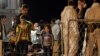 FILE - Migrants wait to disembark from the Italian Navy Ship "Grecale" at Pozzallo harbour, Sicily, May 13, 2014. 