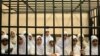 Egyptian women supporters of ousted President Mohamed Morsi stand inside the defendants' cage in a courtroom in Alexandria, Egypt, Nov. 27, 2013.