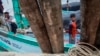 FILE - Migrant fishermen from Myanmar work on a boat after returning from the ocean to Ban Nam Khem, Thailand, Dec. 14, 2014. 