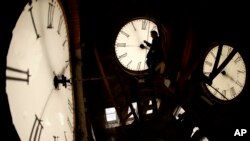 ARCHIVO - El conserje Ray Keen inspecciona la esfera de un reloj de 100 años de antigüedad que se encuentra en la cima del Palacio de Justicia del condado de Clay, el 8 de marzo de 2014, en Clay Center, Kansas. (Foto AP/Charlie Riedel)