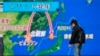 A man stands in front of a huge screen showing TV news program reporting North Korea's missile launch, in Tokyo, Nov. 29, 2017. 