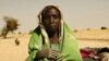 A newly arrived refugee from the Darfur region of Sudan rests next to her belongings in Seneit, Birak area, eastern Chad (file)