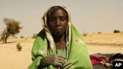 A newly arrived refugee from the Darfur region of Sudan rests next to her belongings in Seneit, Birak area, eastern Chad (file)