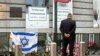 FILE - A man pays respects prior to a service for victims of a shooting — alleged to have been carried out in May by French-Algerian Mehdi Nemmouche — at the Jewish Museum in Brussels, June 2, 2014.