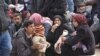 Syrians that evacuated the eastern districts of Aleppo rest while waiting to board buses, in a government-held area in Aleppo, Syria in this handout picture provided by SANA, Nov. 29, 2016.