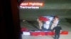 An Egyptian government channel broadcasts an honor guard carrying the casket of a slain policeman with 'Egypt Fighting Terrorism' banner on screen, August 8, 2013.