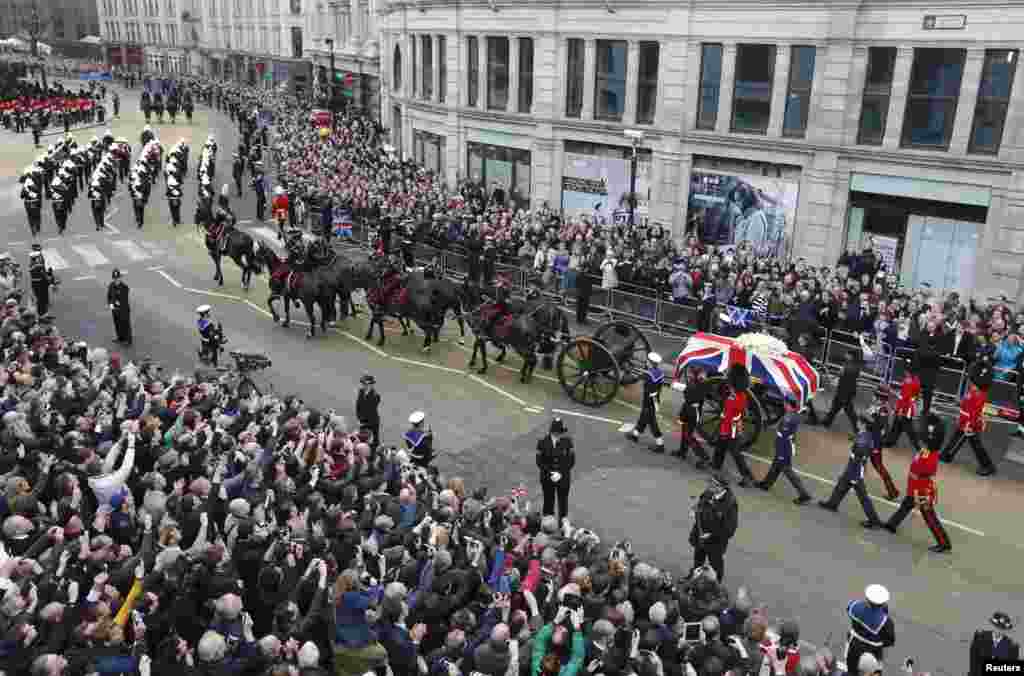 Crowds gather to observe the funeral procession of former British prime minister, Margaret Thatcher, as it travels along Ludgate Hill to her funeral service at St Paul's Cathedral, in London April 17, 2013. 