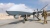 U.S. Air Force officer passes in front of a MQ-9 Reaper drone, one of a squadron that has arrived to step up the fight against the Taliban, at the Kandahar air base, Afghanistan, Jan. 23, 2018. 
