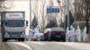 FILE - Workers disinfect passing vehicles in an area experiencing an African swine fever outbreak on the outskirts of Beijing, China, Nov. 23, 2018. 
