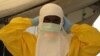 FILE - A health worker adjusts protective gear at a Doctors Without Borders' Ebola treatment unit in Conakry, Guinea. (VOA / Carol Guensburg) 