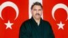 FILE - In this file photo provided by the Turkish Intelligence Service on Feb. 18, 1999, Kurdish rebel leader Abdullah Ocalan stands in front of Turkish flags before being interrogated by Turkish officials at the prison-island of Imrali , Turkey.