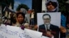 A Cambodian opposition party supporter, right, holds a portrait photo of an opposition senator Hong Sok Hour during a protest in front of the Phnom Penh Municipal Court, in Phnom Penh, Cambodia, Saturday, Aug. 15, 2015. 