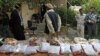 FILE - Afghan police display seized heroine at a police station in Jalalabad. 