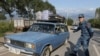 Refugees from Nagorno-Karabakh region drive a car past an Armenian checkpoint in the village of Kornidzor, Armenia, Sept. 24, 2023. 