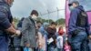 Migrants wait to board on buses outside Moria camp on their way to the port of Mytilene, on the northeastern Aegean island of Lesbos, Greece, May 3, 2020.
