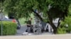 FILE - Police appear to setup a remotely operated robot during a stand off in Hutchins, Texas, June 13, 2015