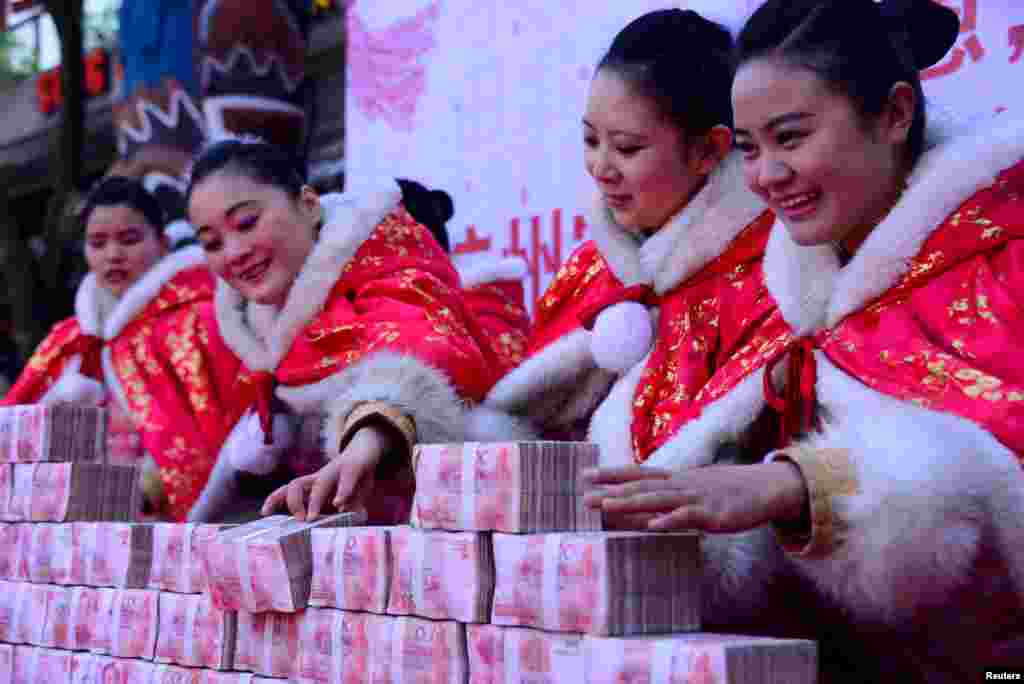 2016年1月26日，在中国杭州一个公园里，工作人员在一场有奖游戏中摆放百元钞票