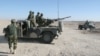 FILE - Afghan National Army soldiers stand guard at a checkpoint on the way to the Sangin district of Helmand province, Afghanistan, Dec. 23, 2015.