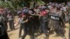 Police officers beat a student protester after detaining him following a crackdown in Letpadan, 140 kilometers (90 miles) north of the country's main city Yangon, Myanmar, Tuesday, March 10, 2015.