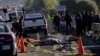 FILE - Police officers and rescue personnel stand near the bodies of people who were killed in a car crash on the outskirts of Puebla, Mexico, Dec. 12, 2017.