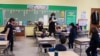 FILE - A teacher calls names for schoolchildren to collect a swab and test themselves for COVID-19 to prevent the spread of the coronavirus disease (COVID-19) in the classroom at South Boston Catholic Academy in Boston, Massachusetts, Jan. 28, 2021. 