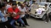 Indian people pull a car by rope and shout slogans during a protest against the price hike in diesel and capping the number of subsidized cooking gas cylinders in Ahmadabad, India, September 14, 2012.