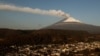 Una nube de cenizas y vapor emerge del volcán Popocatépetl se observa en esta foto desde el poblado de Santiago Xalizintla, en México, el 12 de mayo de 2023.