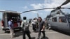 Medical officers prepare a sample for loading on to a helicopter for testing in Sihanoukville, Cambodia, Thursday, Feb. 13, 2020. The Westerdam cruise ship, turned away by four Asian and Pacific governments due to virus fears, anchored Thursday off…
